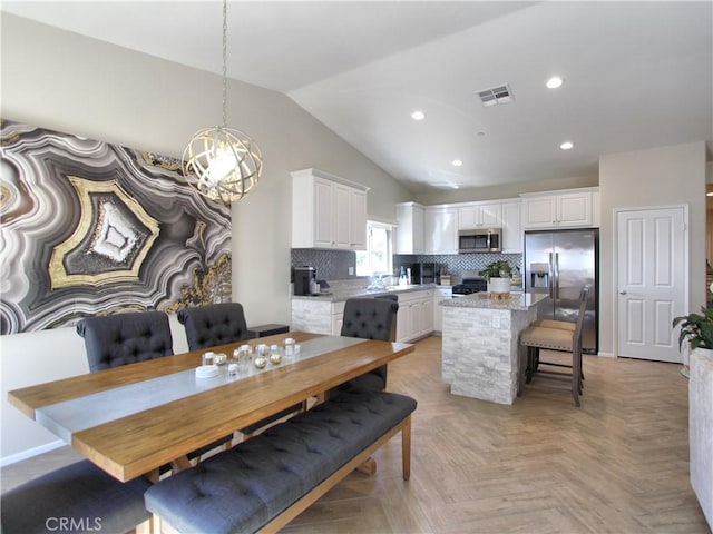 dining area with lofted ceiling and light parquet flooring