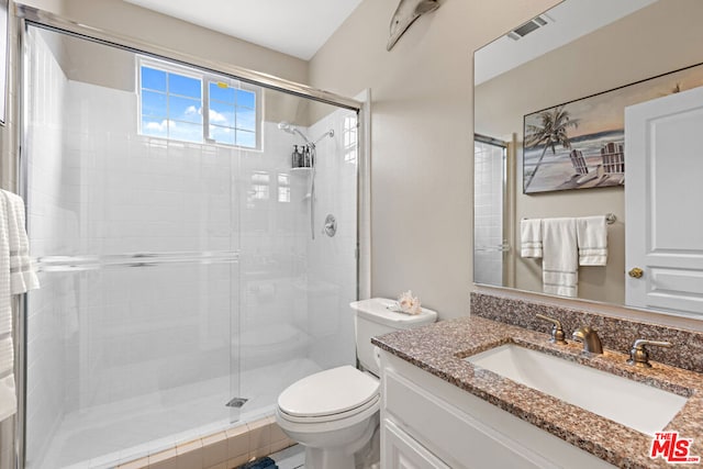 bathroom featuring vanity, toilet, and an enclosed shower