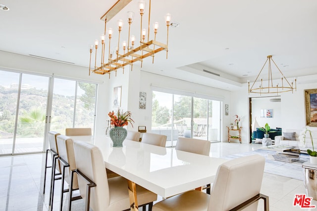 tiled dining area with a wealth of natural light and a tray ceiling