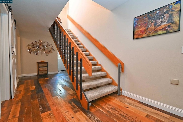 staircase featuring hardwood / wood-style floors and a barn door