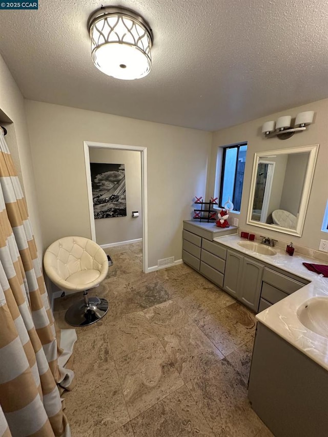 bathroom with vanity and a textured ceiling