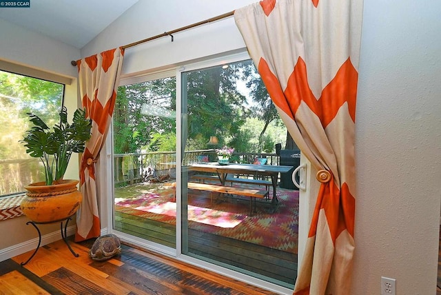 doorway featuring hardwood / wood-style flooring and vaulted ceiling