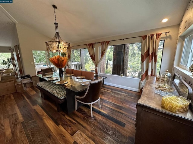 dining area with an inviting chandelier, dark hardwood / wood-style flooring, vaulted ceiling, and a wealth of natural light