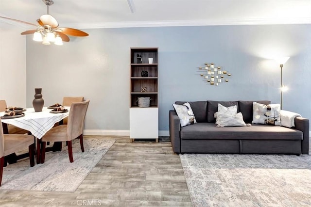 living room with crown molding, ceiling fan, and wood-type flooring