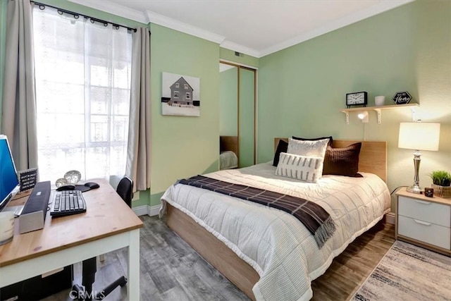 bedroom featuring a closet, ornamental molding, and wood-type flooring