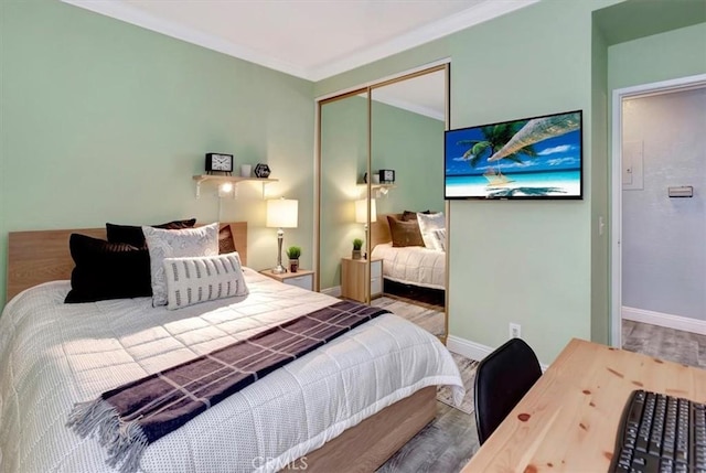 bedroom featuring wood-type flooring, crown molding, and a closet