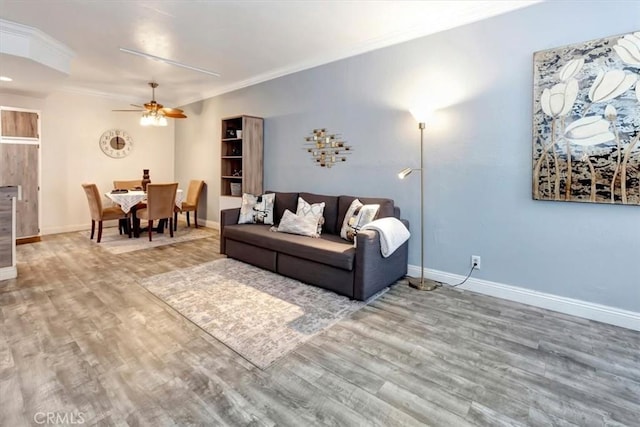 living room featuring crown molding, ceiling fan, and hardwood / wood-style floors