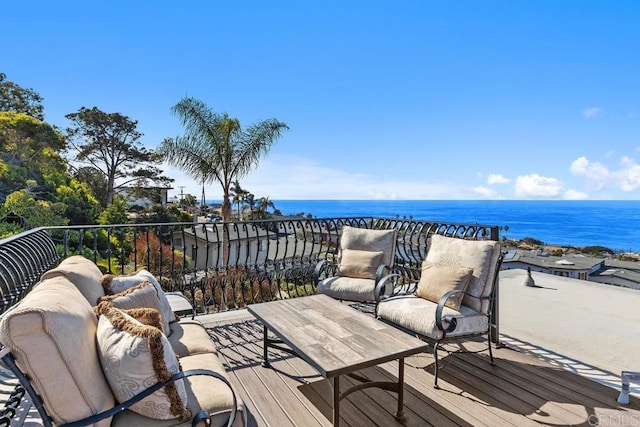 wooden terrace with a water view and outdoor lounge area