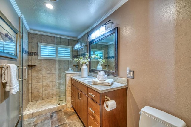 bathroom featuring vanity, ornamental molding, a textured ceiling, a shower with shower door, and toilet