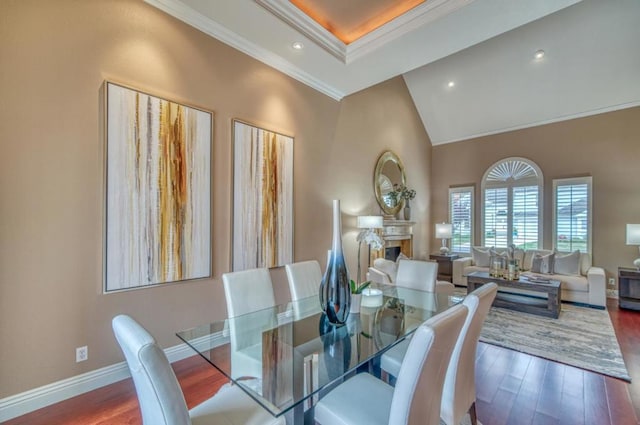 dining area featuring crown molding, dark wood-type flooring, and a towering ceiling