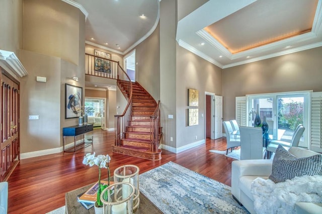 living room featuring ornamental molding, plenty of natural light, dark hardwood / wood-style flooring, and a towering ceiling