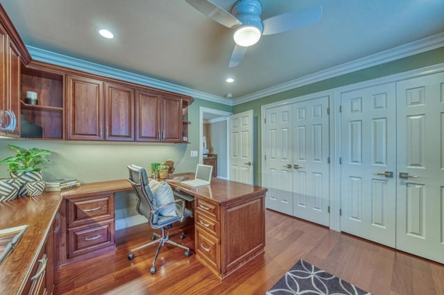 home office featuring crown molding, wood-type flooring, built in desk, and ceiling fan