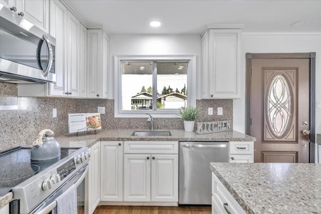 kitchen with stainless steel appliances, a healthy amount of sunlight, sink, and white cabinets