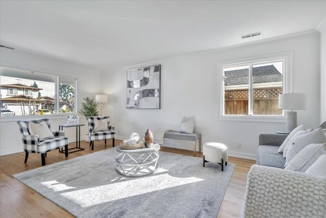 living room with crown molding and light hardwood / wood-style floors