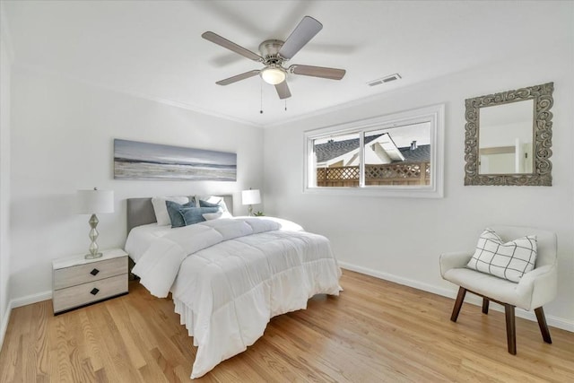 bedroom with ceiling fan, ornamental molding, and light hardwood / wood-style floors