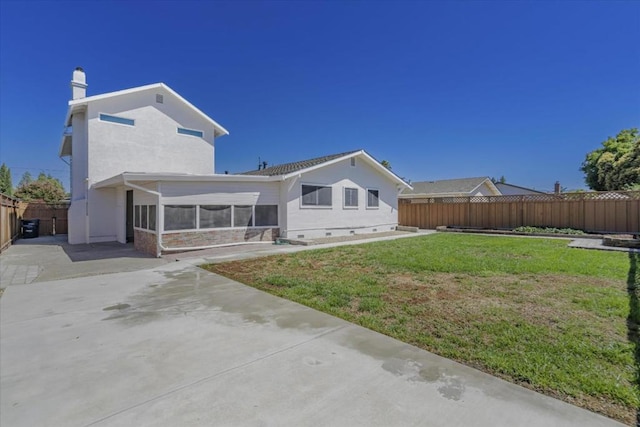 rear view of house featuring a patio, a sunroom, and a lawn