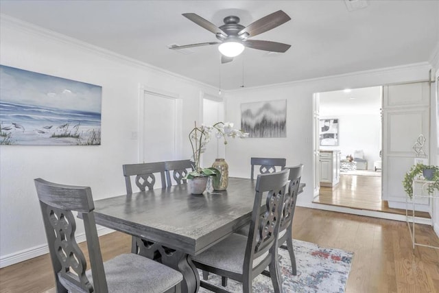 dining space with crown molding, hardwood / wood-style flooring, and ceiling fan