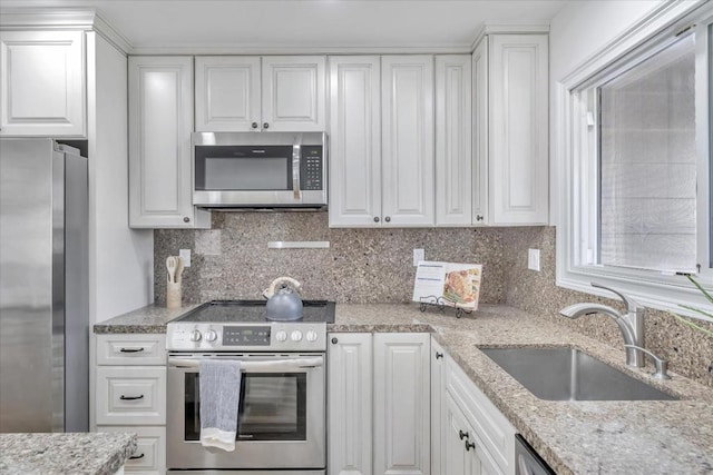 kitchen featuring white cabinetry, appliances with stainless steel finishes, sink, and backsplash