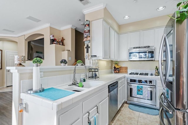 kitchen featuring appliances with stainless steel finishes, white cabinets, and kitchen peninsula