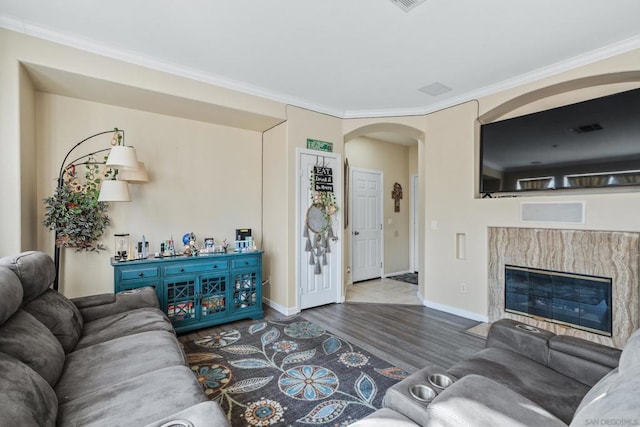 living room featuring crown molding, wood-type flooring, and a premium fireplace