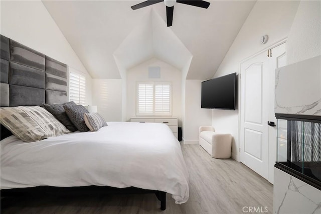 bedroom with vaulted ceiling, ceiling fan, and light wood-type flooring