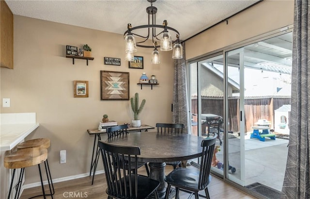 dining area featuring hardwood / wood-style floors and a notable chandelier