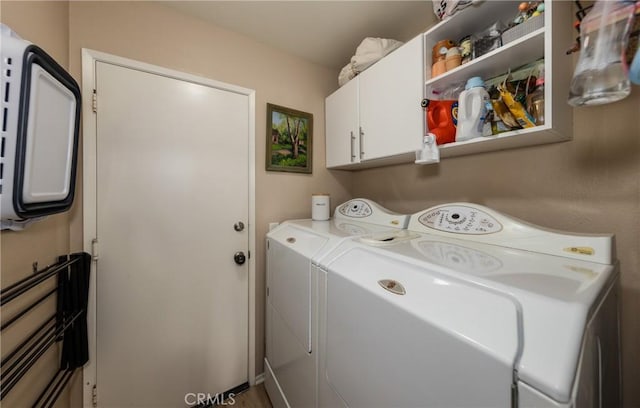 washroom with washing machine and dryer and cabinets