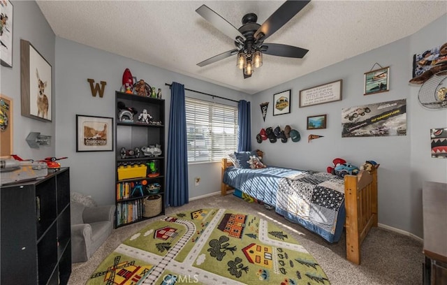 carpeted bedroom featuring ceiling fan and a textured ceiling