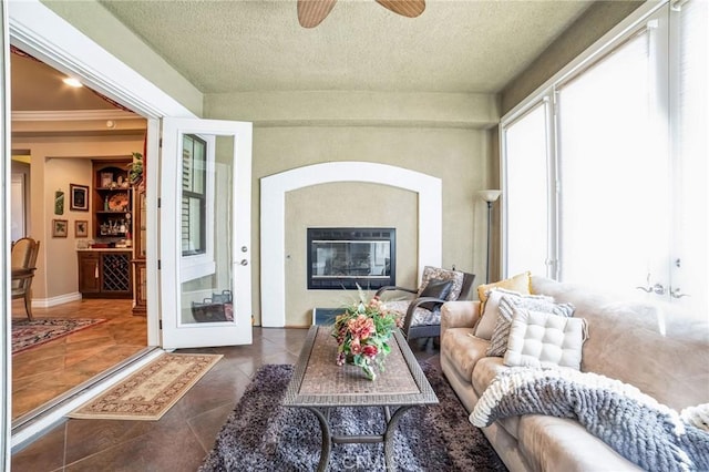 tiled living room with ceiling fan and a textured ceiling