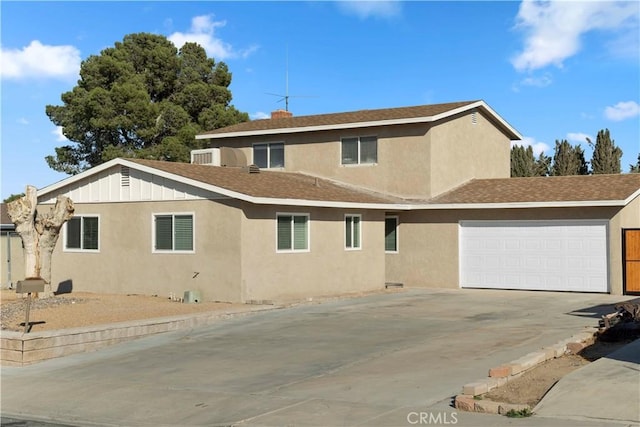 view of front facade with a garage, concrete driveway, a shingled roof, and stucco siding