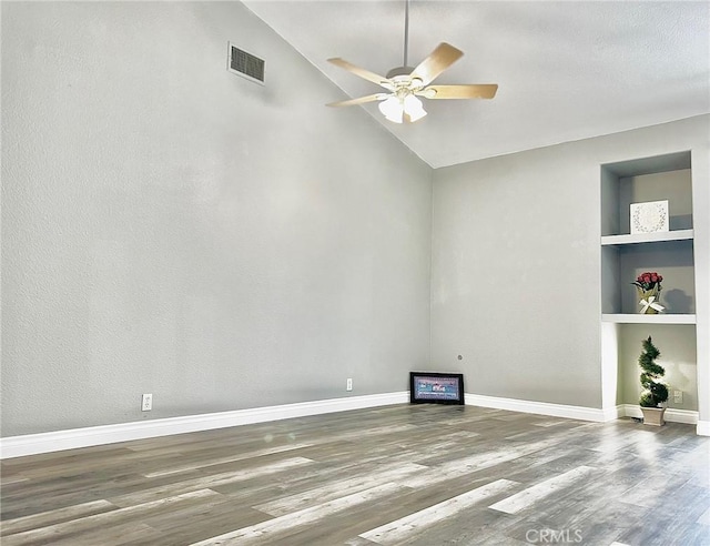 unfurnished room featuring hardwood / wood-style flooring, vaulted ceiling, ceiling fan, and built in shelves