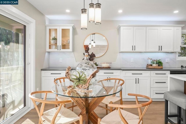 kitchen with hardwood / wood-style flooring, decorative light fixtures, tasteful backsplash, and white cabinets