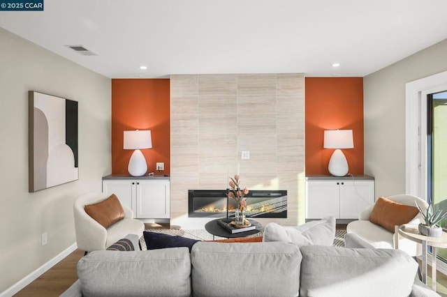 living room featuring hardwood / wood-style floors and a tile fireplace