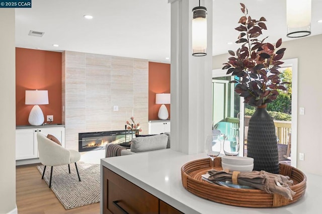 bathroom with a tile fireplace and hardwood / wood-style floors