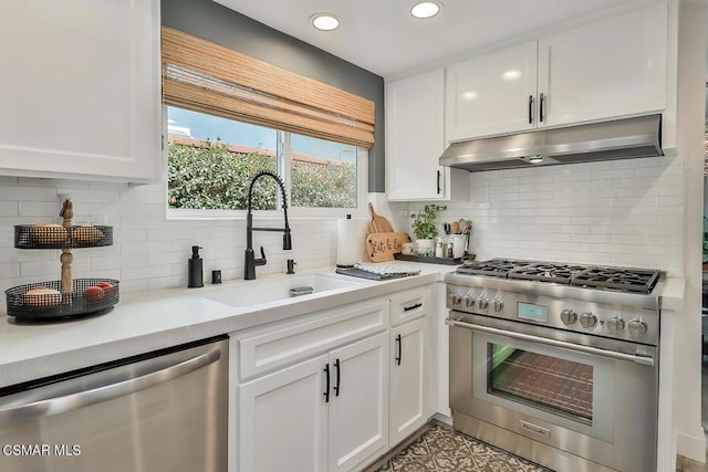 kitchen featuring sink, white cabinetry, light stone counters, stainless steel appliances, and decorative backsplash