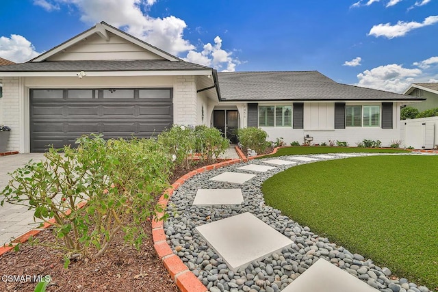 single story home featuring a garage and a front lawn