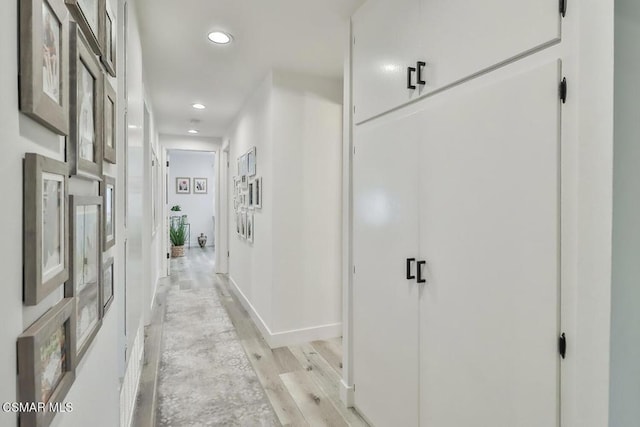 hallway with light hardwood / wood-style floors