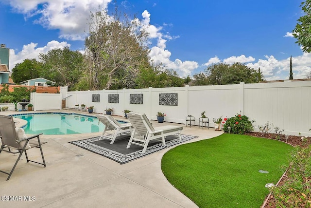 view of pool featuring a lawn and a patio area