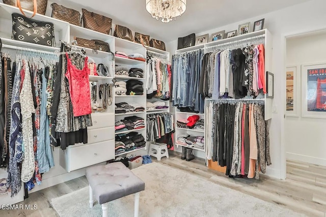 spacious closet featuring hardwood / wood-style floors and a chandelier