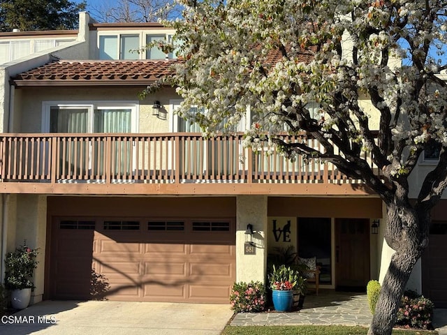 rear view of house featuring a garage and a balcony