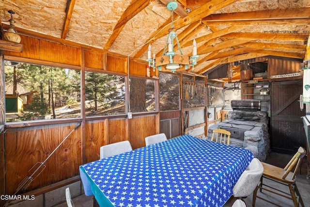 interior space with lofted ceiling and wooden walls