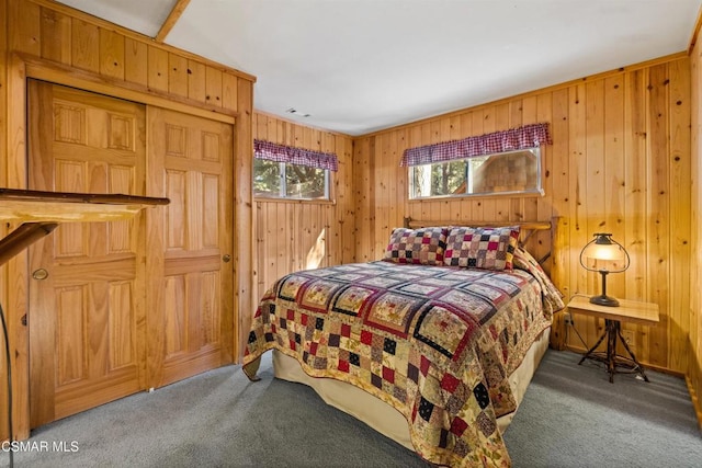 bedroom with carpet floors and wooden walls