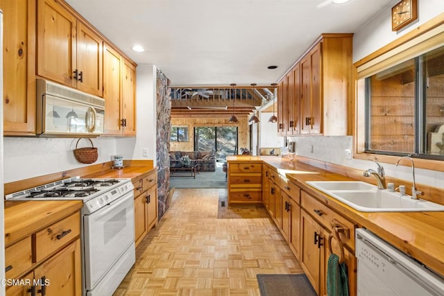 kitchen featuring light parquet flooring, sink, and white appliances