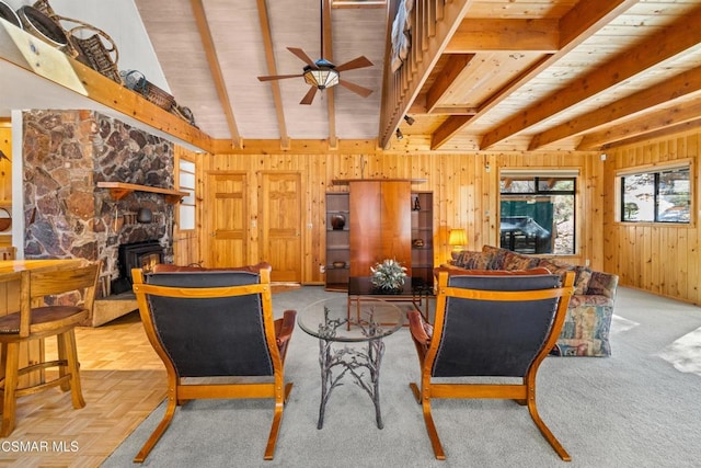 living room with a fireplace, wooden walls, lofted ceiling with beams, ceiling fan, and wooden ceiling