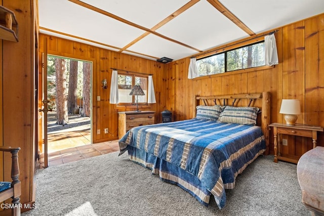 bedroom with light colored carpet, access to exterior, multiple windows, and wood walls