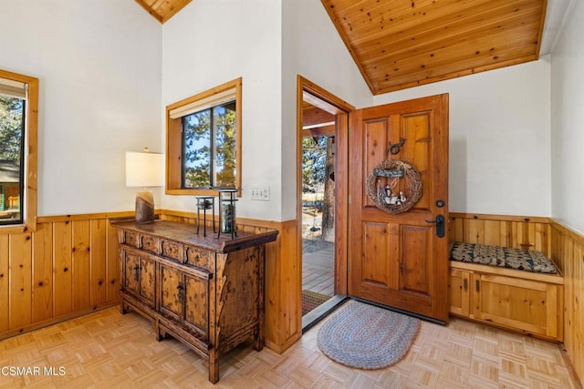 entrance foyer featuring a wealth of natural light, wooden walls, and light parquet flooring