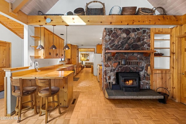 kitchen with sink, hanging light fixtures, fridge, beamed ceiling, and light parquet floors