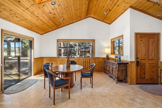 dining room with wood walls, a healthy amount of sunlight, and wooden ceiling