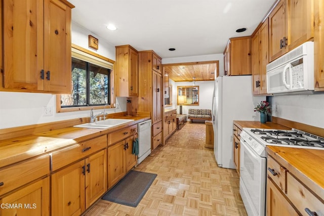 kitchen featuring white appliances, light parquet flooring, butcher block counters, and sink