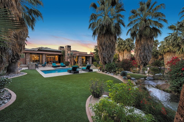 yard at dusk with an outdoor hangout area and a patio area